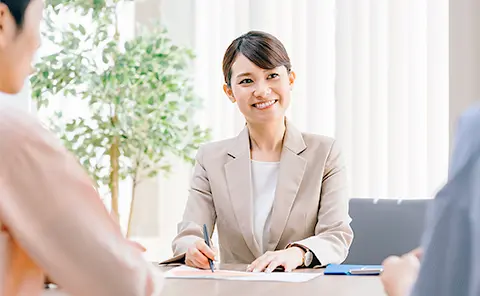 女性行員が笑顔で対応している様子